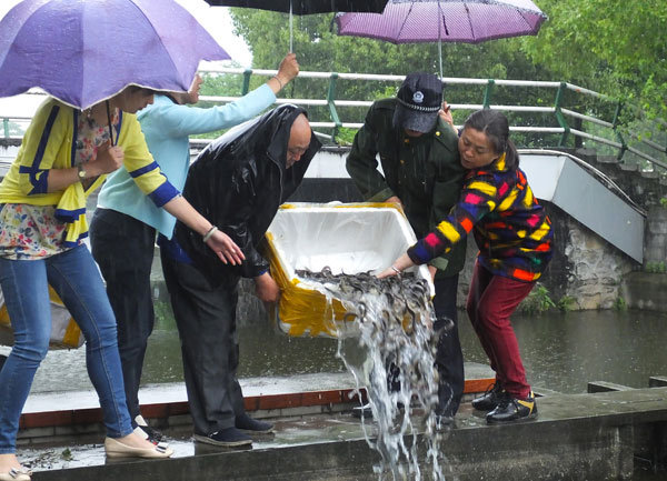 People release more than 50 kg of loaches into a river in Yichang, Hubei province, to celebrate the Buddha's birthday on May 14. (Photo by Liu Junfeng/China Daily)