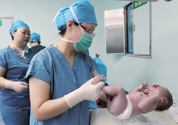 Medical staff check a newborn baby at Tangdu Hospital in Xi'an, Shaanxi province, in February. The boy was born from an embryo frozen 12 years ago, a record for the Chinese mainland. Ruan Banhui / For China Daily