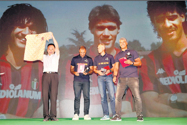 Retired stars Ruud Gullit, Marco van Basten and Frank Rijkaard of the Netherlands exchange gifts with Zhong Bingshu, principal of Capital University of Physical Education and Sports, at the launch ceremony in Beijing on Tuesday. Li Linlin / For China Daily