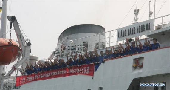 Members of the expedition team wave hands on Xiangyanghong 09, carrier of China's manned deep-sea submersible Jiaolong, in Qingdao, east China's Shandong Province, July 13, 2016. (Xinhua/Zhang Xudong) 