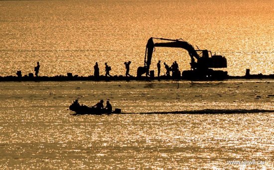 Armed police soldiers prepare for the breach of the embankment on the dike of Niushan Lake in central China's Hubei Province, July 13, 2016.  (Xinhua/Xiao Yijiu)
