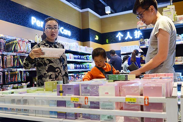 A family of three shopping at a duty-free store at Zhengzhou Airport, Henan province. ZHANG TAO / FOR CHINA DAILY