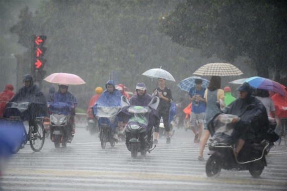 Bikers travel in heavy rain in Yangzhou, east China's Jiangsu Province, July 14, 2016. Heavy rain hit most parts of Jiangsu as the National Meteorologival Center issued a blue rainstorm alert on Thursday. (Xinhua/Meng Delong)
