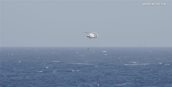 A helicopter is sent to rescue a crew member during an emergency drill at seas near Sansha in south China's Hainan Province, July 14, 2016. An emergency drill involving 13 ships and a helicopter was held Thursday morning at seas near Sansha in Hainan, the city's marine bureau said. (Xinhua/Liu Deng) 