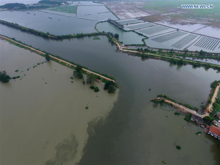 The aerial photo taken on July 17, 2016 shows a breached dyke on Kaotian River in Dingzijie Village of Huangmei County, central China's Hubei Province. A dyke breach occured here around 3:00 a.m. on Sunday. The local government has transfered local villagers to safe areas while blocking the breach. (Xinhua/Xiong Qi)