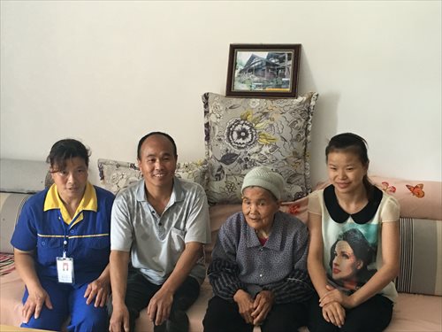 Xiong Shiguo (second from left) and his family sit in the living room of their new apartment. (Photo: GT/Zhang Yu)