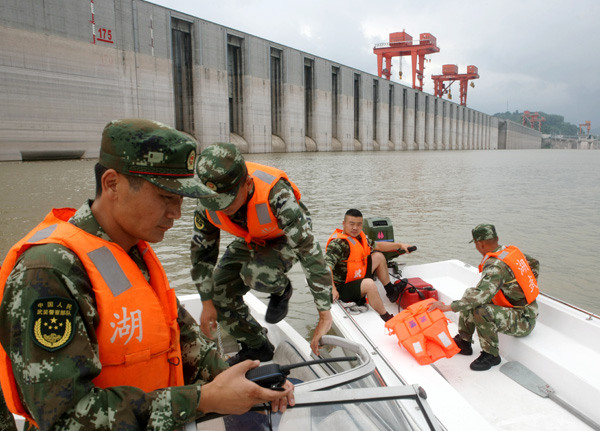 Police officers prepare to patrol the area around the Three Gorges Dam reservoir on July 13 in Yichang, Hubei province. The reservoir can hold 39.3 billion cubic meters. (Photo by Sun Ronggang/CHINA DAILY)