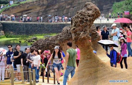 Tourists visit Yehliu Geopark in New Taipei of southeast China's Taiwan, May 2, 2016. The geopark features stunning geological landscape formed by wave attack, rock weathering, earth movement and crustal movement, which make it a famous destination for tourists. (Xinhua/Wei Peiquan) 