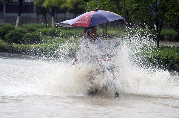 Residents contend with water in Zhangjiajie, Hunan province, on Monday, after the city was hit by torrential rain.GUO LILIANG/CHINA DAILY