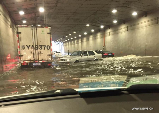 Photo taken by a cellphone shows vehicles stranded in water at a flooded tunnel outside the Beijing West Railway Station in Beijing, capital of China, July 20, 2016. Beijing's meteorological bureau issued an orange alert for rainstorm Wednesday noon. (Xinhua/Liu Guannan) 