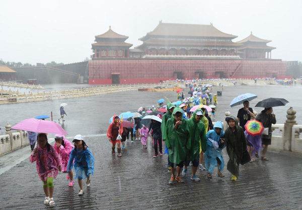 Tourists visit the Forbidden City in rain in Beijing on July 20, 2016. (Photo/Xinhua)