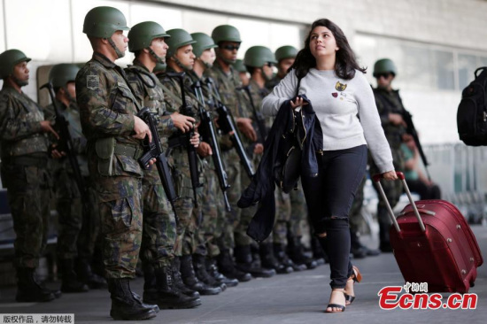 A passenger walks as Brazilian Air force soldiers patrol the Tom Jobim International airport ahead of the 2016 Rio Olympics in Rio de Janeiro, Brazil, July 19, 2016. (Photo/Agencies)