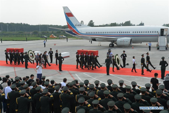 Honor guards carry the coffins of two Chinese UN peacekeepers during a ceremony at Zhengzhou Xinzheng International Airport in Zhengzhou, capital of central China's Henan Province, July 20, 2016.  (Xinhua/Zhang Yongjin) 