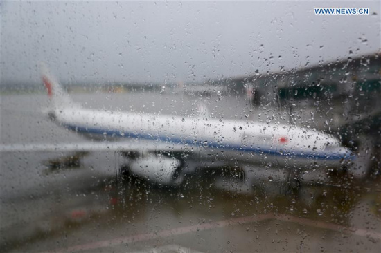 A plane is seen at the apron of the Beijing Capital International Airport in Beijing, capital of China, July 20, 2016. A total of 212 flights have been canceled at Beijing Capital International Airport due to the continuous rainfall. (Xinhua/Fu Qi) 