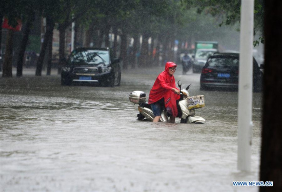 A resident rides on a waterlogged road in Shijiazhuang, capital of north China's Hebei Province, July 20, 2016. (Xinhua/Wang Xiao) 