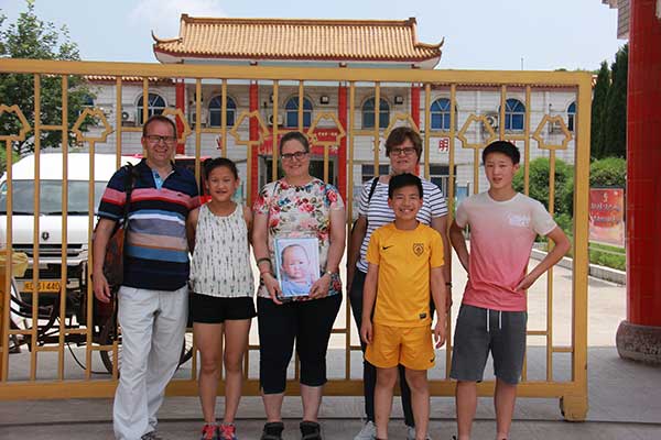 Erika Olzheim (third from left) adopted Callista, a Chinese girl (second from left). Her sister, Andrea De Baar (fourth from left) adopted two boys. They visited the orphanage in Anhui province, where Callista spent her first 18 months.(Zhu Lixin/China Daily)