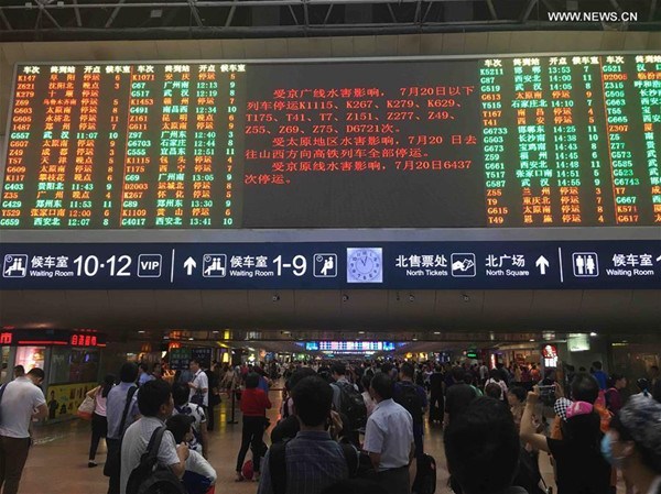 passengers checking train information at the Beijing West Railway Station in Beijing, capital of China on July 20, 2016.The continuous rain led to delay or suspension of several trains to and from Beijing. (Photo:Xinhua/Wang Jianhua)