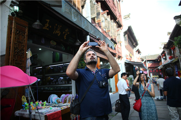 Marco Meccarelli takes a photo on Tunxi Old Street in Huangshan city, East China's Anhui province, on July 17, 2016. The Anhui trip was part of the 2016 Visiting Program for Young Sinologists. (Photo/Chinaculture.org)