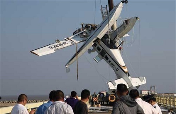 The seaplane that crashed into the Hangzhou Bay near Shanghai yesterday afternoon is lifted out of water. A co-pilot and four passengers were killed after it hit a bridge on takeoff. (Xinhua)