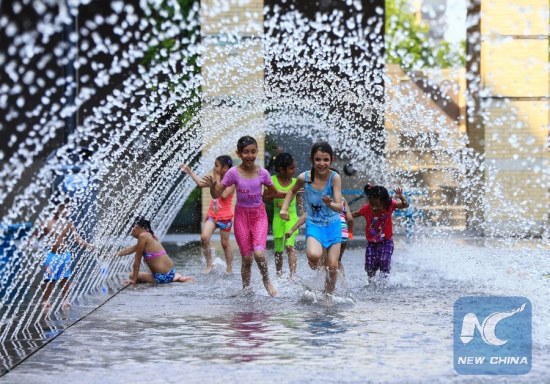Children cool off in a wading pool in Toronto, Canada, June 20, 2016. Toronto issued an extreme heat alert on Monday, and the forecasted high was 34 degrees Celsius. (Xinhua/Zou Zheng)