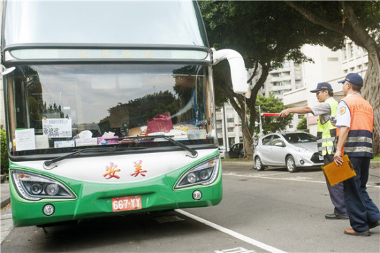 Safety inspectors check a tour bus in Taipei, Taiwan, on Thursday in the wake of a fire that killed 26 people, including 24 mainland tourists, on Tuesday. (Photo/China Daily))