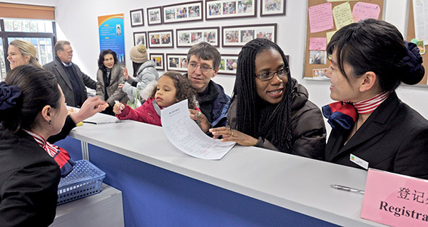 A family from the United States checks in at the Lianyang International Community service center in the Pudong New Area of Shanghai. The center provides services such as residence registration, consultation and exchange of information on daily life. (Photo/China Daily)