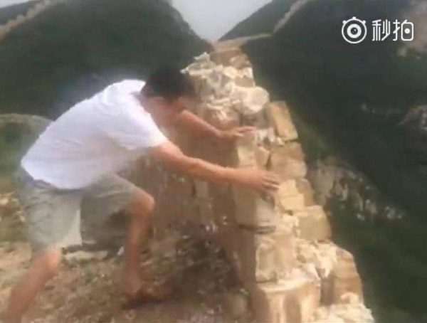 Screenshot from an online video shows a man vandalizing the Great Wall. (Photo/Screenshot from online video)