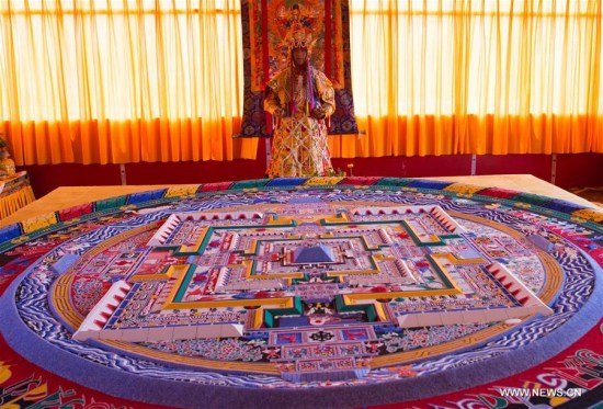 The 11th Panchen Lama Bainqen Erdini Qoigyijabu is seen near a mandala made of colored sand in Xigaze, southwest China's Tibet Autonomous Region, July 24, 2016. 
