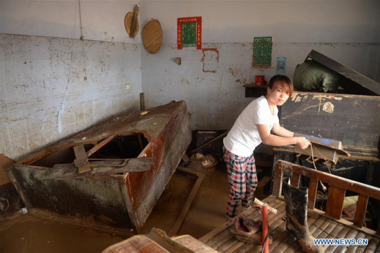 A villager clears the debris at her home in Nanshitun village of Xingtai City, north China's Hebei Province, July 24, 2016. (Xinhua/Wang Xiao) 