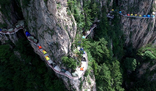 Backpackers set up tents on a plank road on a cliff in Laojun Mountain in Luoyang, Henan province, over the last weekend. (Photo by Wang Zhongju/China Daily)