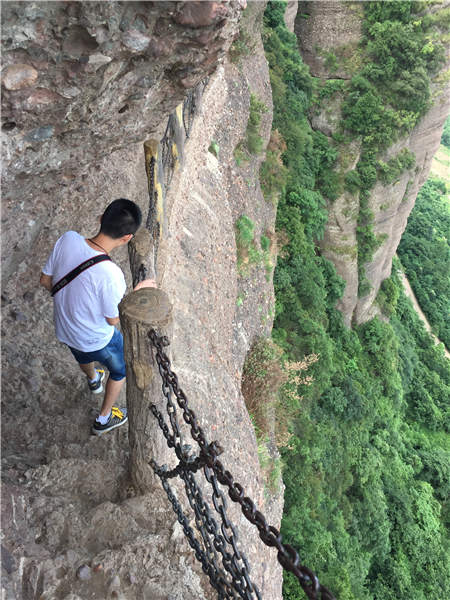 A tourist walks carefully along the mountain pass, a section of the ancient Shu Road in Guangyuan. Photos by Yang Feiyue / China Daily