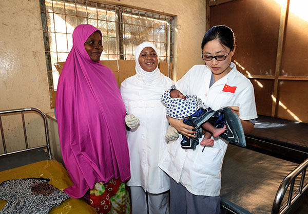 Chinese medical worker Yu Chunqing from Wuxi, Jiangsu province, checks a newborn baby in the China-funded hospital in Zanzibar, Tanzania. ZHOU XIAOXIONG/XINHUA