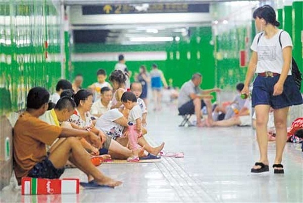 Residents who dont have air conditioners cool off at West Jinshajiang Road Station.(Wei Yi)