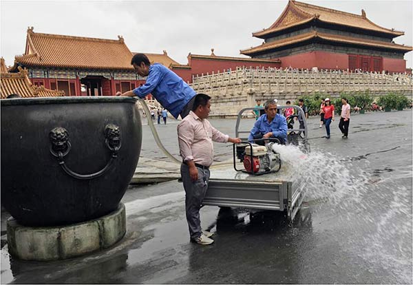 Rainwater is pumped out of a jar in the Forbidden City after heavy downpours in Beijing last week. (Provided To China Daily)