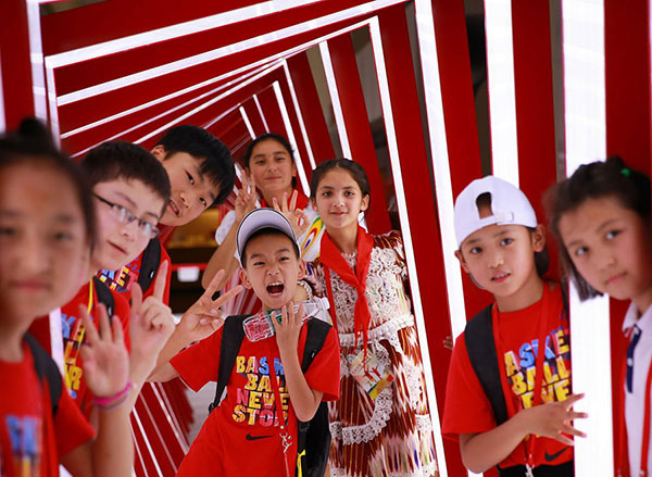 Children of migrant workers pose for a photo during their trip to Peking University on Friday. (Photo by Zou Hong/China Daily)