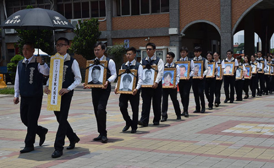 The framed photos of 26 people who died in a tour bus fire in Taiwan on July 19 are escorted to a memorial hall in Taoyuan city on Monday. (Photo/China News Service)