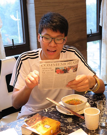 Li Anqiang reads an English-language story of a volunteer of the Wenchuan earthquake in Sichuan province.(Photo by Huang Zhiling/chinadaily.com.cn)