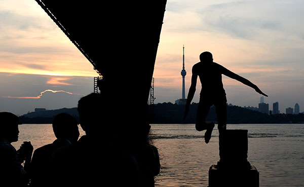 A resident of Wuhan, Hubei province, jumps into the Yangtze River for relief from the heat on Wednesday. JIN SILIU/CHINA DAILY