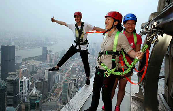 Visitors walk at 340.6 meters above the ground at a new attraction on a skyscraper in Shanghai. GAO ERQIANG/CHINA DAILY