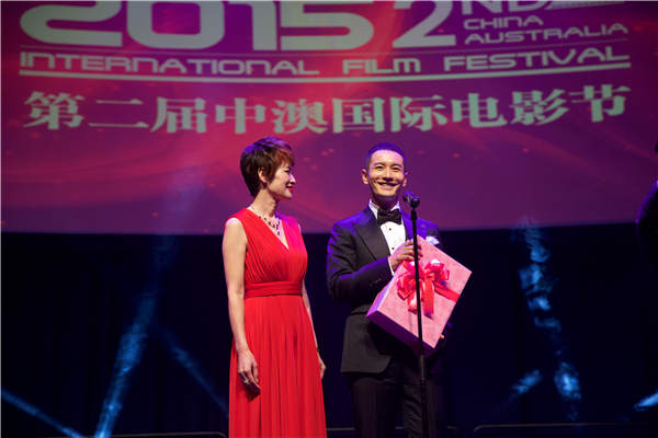 Tina Liu, executive president of the China Australia Film Festival, presents a wedding gift to Chinese actor Huang Xiaoming at last year's festival. Provided To China Daily