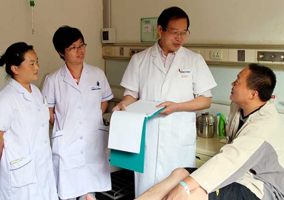Yu Zhenqiu, director of the hypertension department at Anzhen Hospital in Beijing, talks to a patient on Friday. (Provided to China Daily)