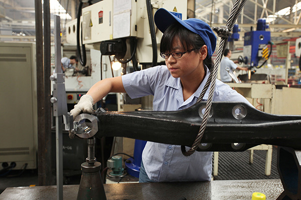 An employee works on a heavy-duty truck production line of the Shaanxi Automobile Holding Group Co Ltd in Xi'an, Shaanxi province. (Wei Yongxian/For China Daily)