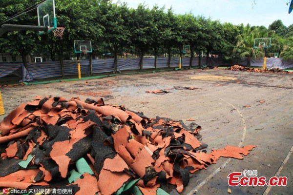 A bulldozer demolishes synthetic running tracks and sports fields at a private elementary school in Chengdu City, the capital of Southwest China's Sichuan Province, June 15, 2016. 