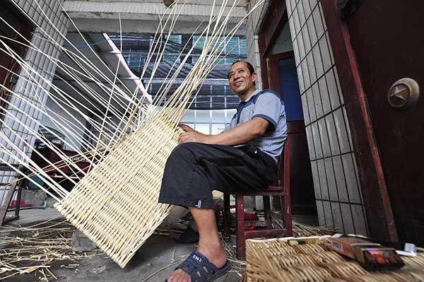 A local villager makes willow products at home. (Photo by Lu Peng/Xinhua)