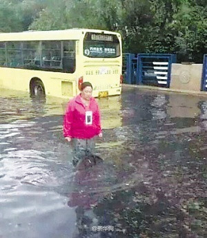 Xun Xiaohong is pictured standing by a manhole on a street in Harbin, capital city of Northeast China's Heilongjiang province, June 12, 2016. (Photo/Xinhua)