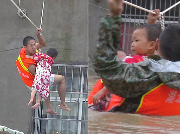 Liu Xiaopeng, a firefighter, uses ropes to rescue a stranded child with the help of comrade in Dawu county, Hubei province, on Friday. (Photo by Wang Jida/China Daily)