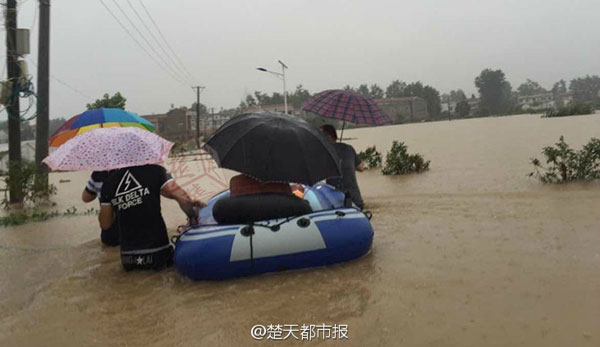 Li Shengping rides in a rubber boat to pick up his bride with the help of his friends on a rainy day in Wuhan, Hubei province, July 2, 2016. (Photo/Sina Weibo)