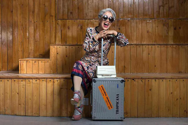 Liang Xide, 80, poses for an undated fashion photo with a suitcase in Shenyang, capital of Northeast China's Liaoning province. (Photo/People's Daily Online)