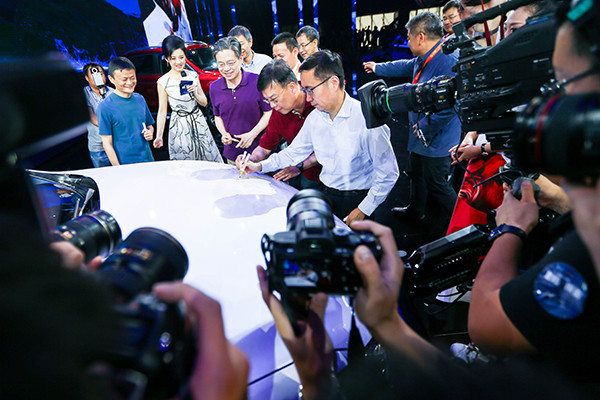 Representatives of Alibaba Group Holding Ltd and SAIC Motor Corp sign on a jointly developed internet-enabled vehicle, which was launched on June 6, 2016 in Hangzhou, Zhejiang province, while Alibaba's Executive Chairman Jack Ma (left) looks on. (Photo/China Daily)