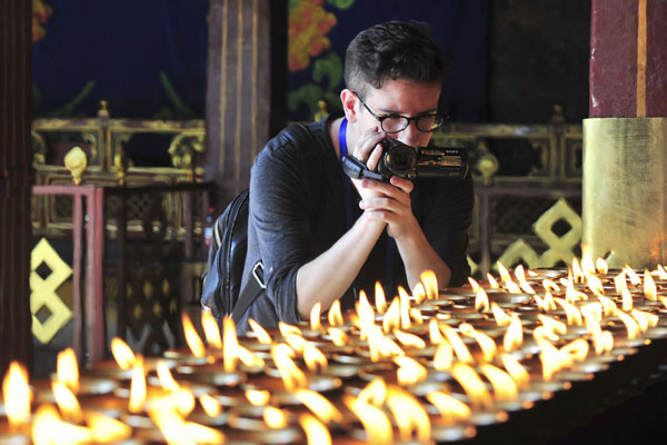 An overseas journalist shoots a video at Jokhang Temple, Lhasa, on Monday. (Photo by Tentsen Shiden/Tibet Daily)